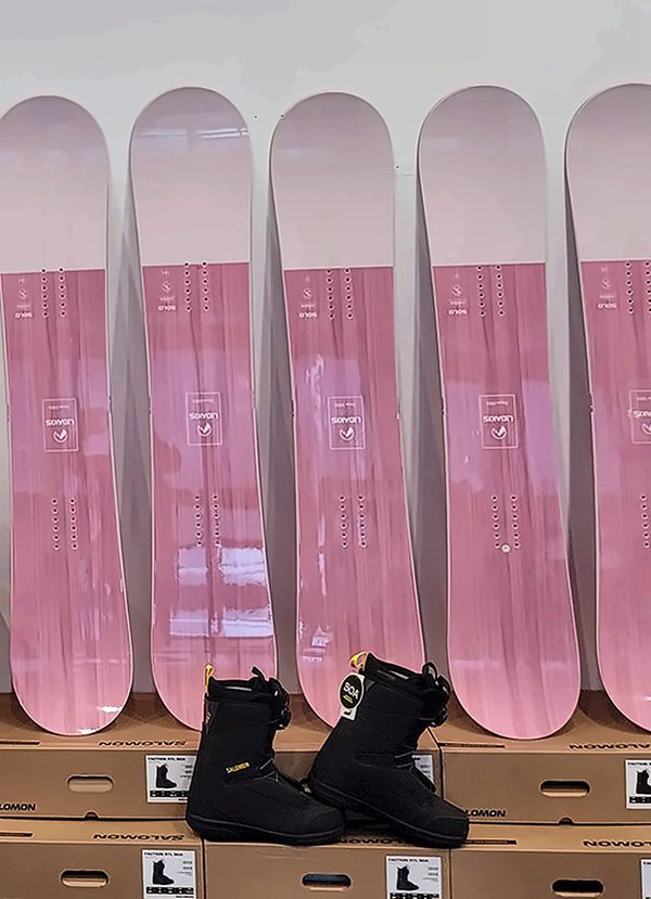매장 벽에 줄지어 세운 분홍 스노우보드와 보드 부츠